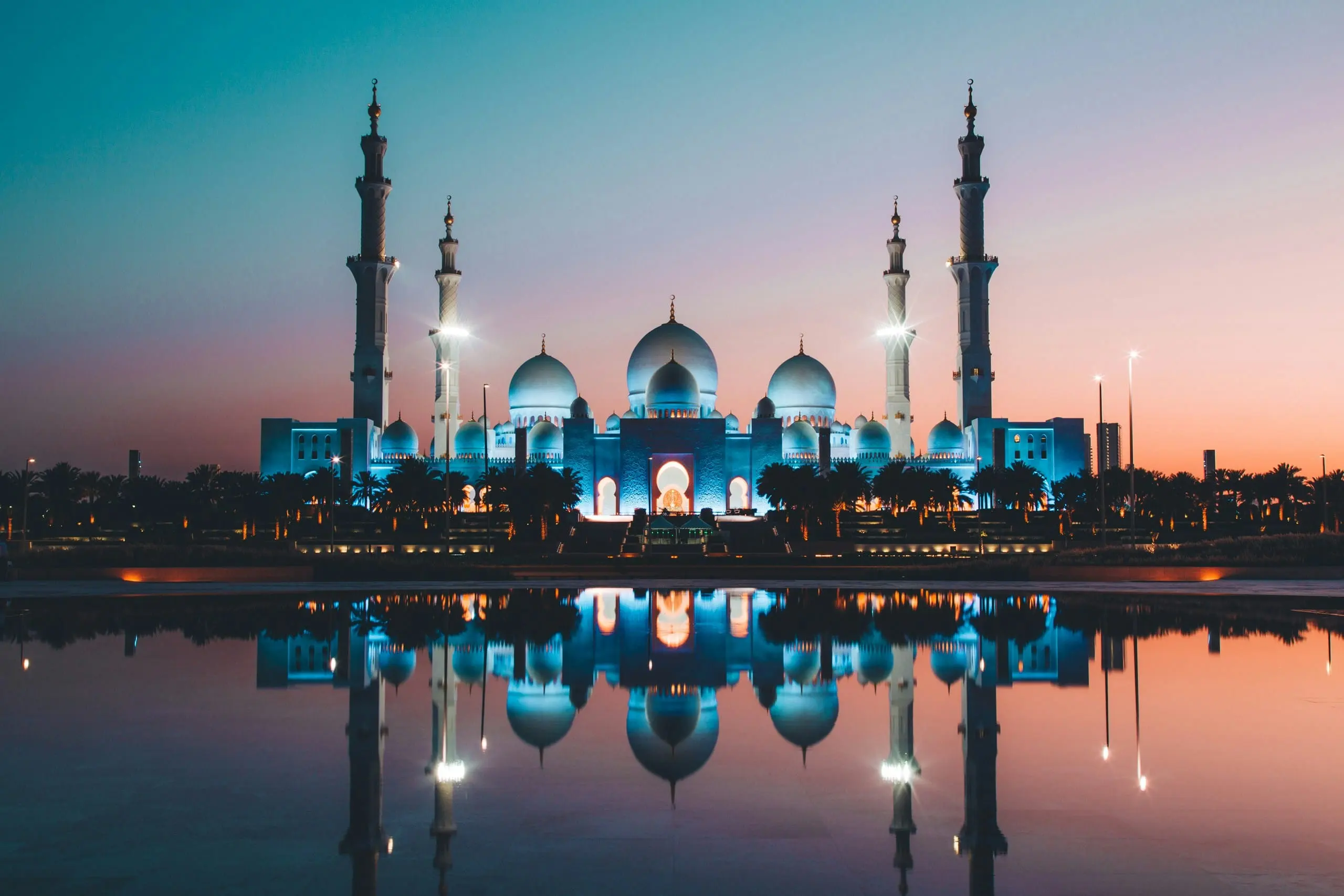 Sheikh Zayed Grand Mosque reflected in still water at dusk
