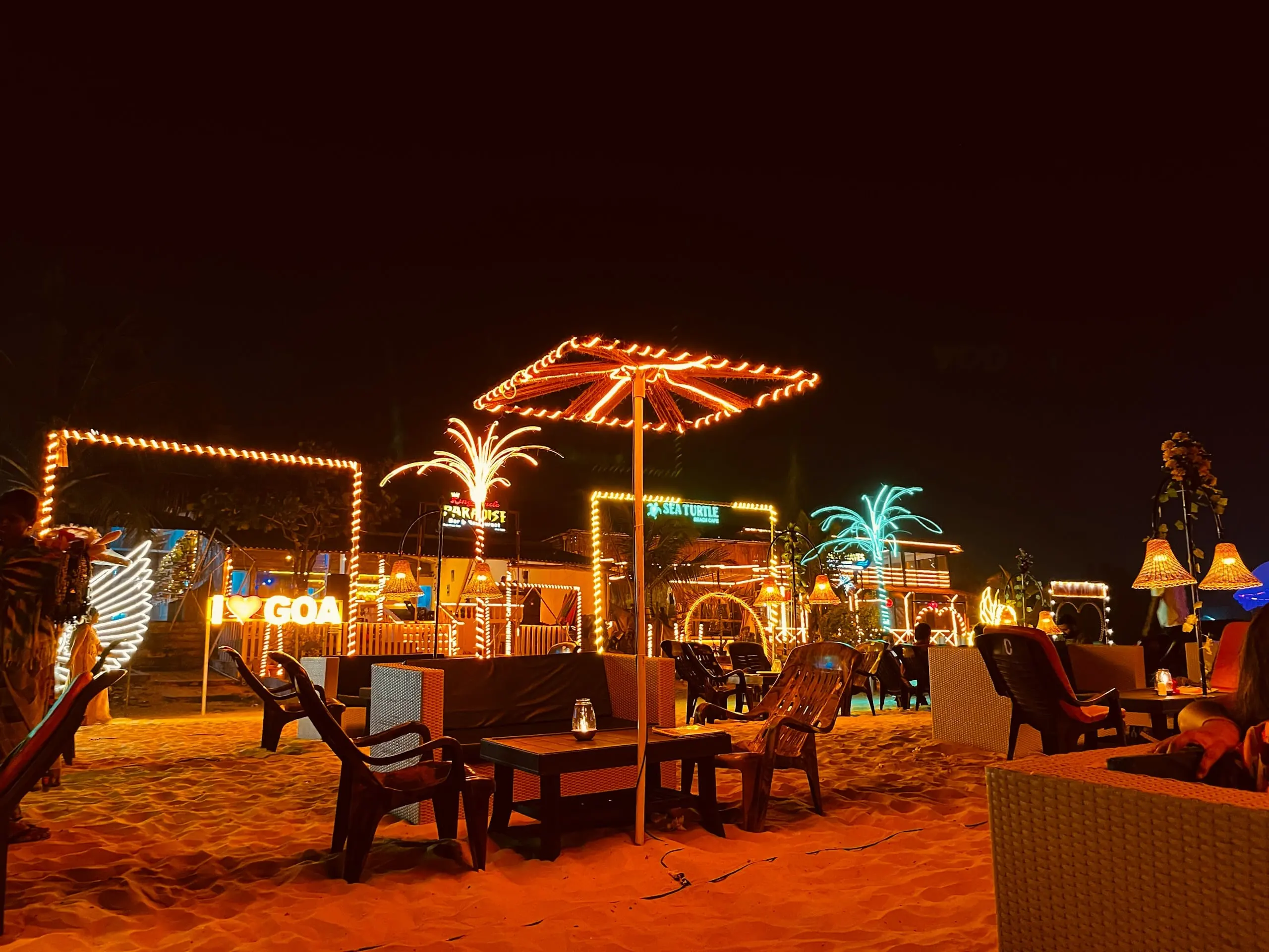 A beach shack in Goa glowing with lights at night