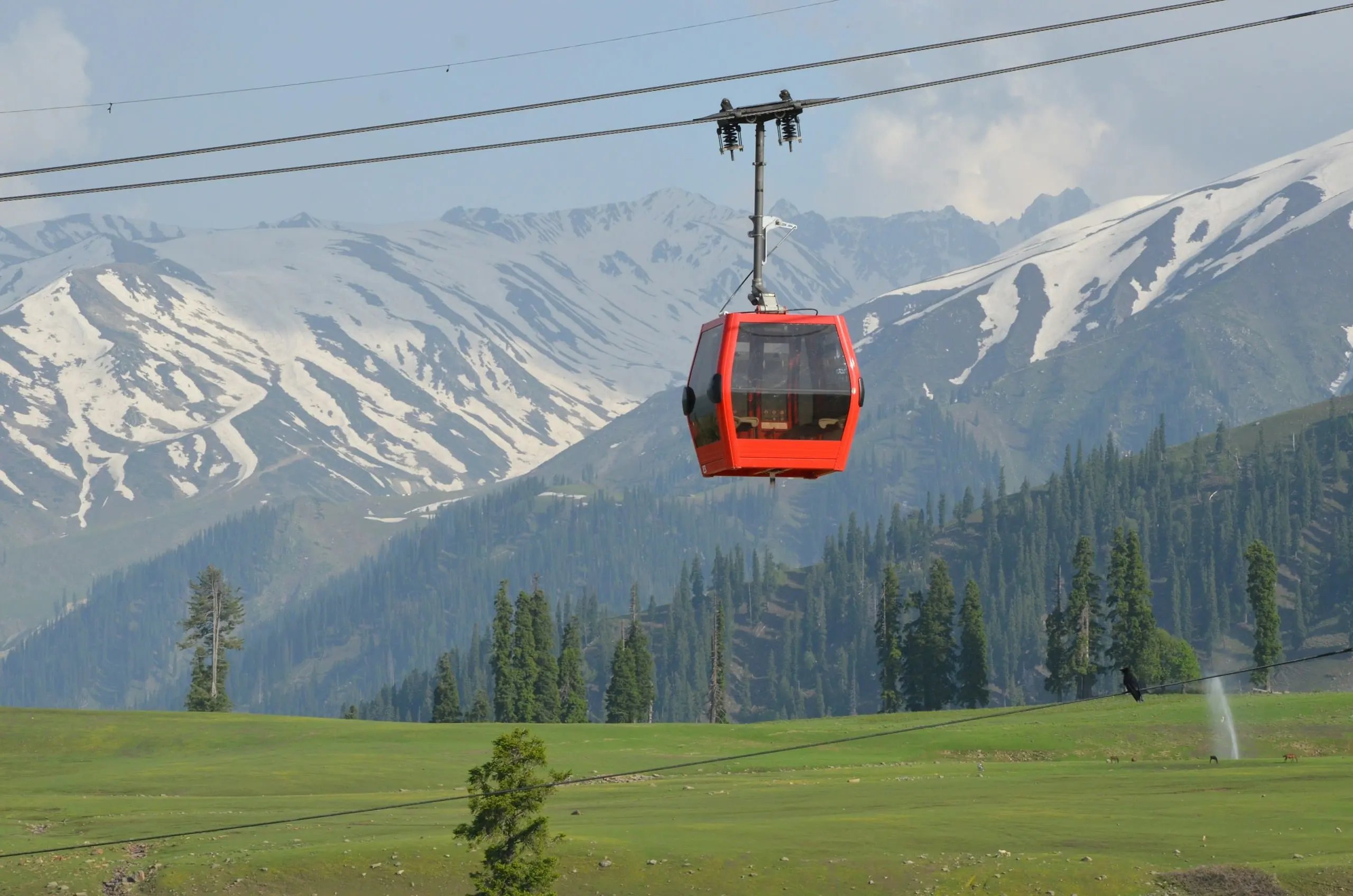 The Gulmarg Gondola above green slopes and snowy peaks